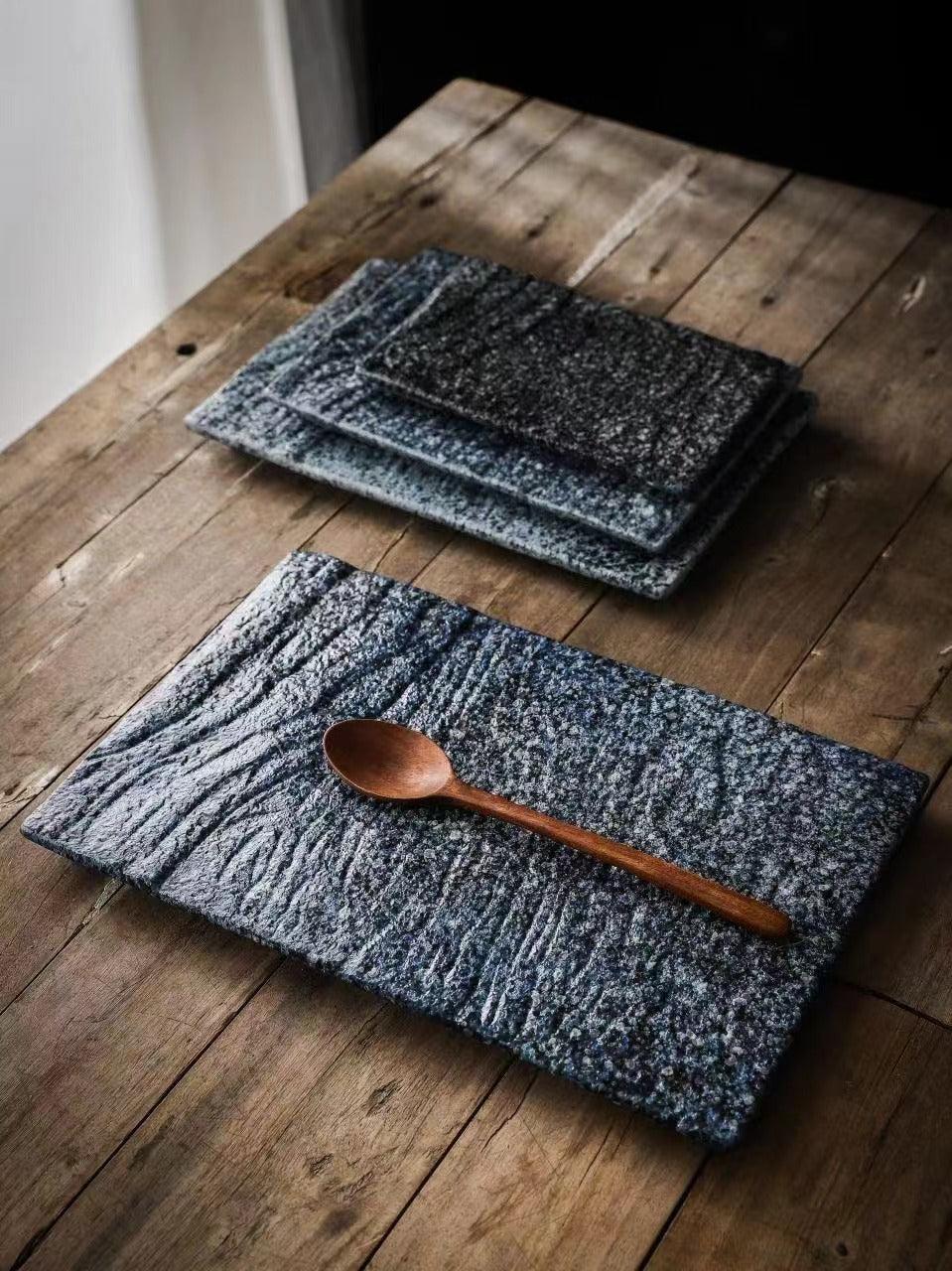 Textured ceramic plates in dark glaze